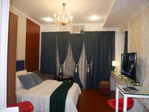 a hotel room with a bed and a television at Trillium Residences Ayala Cebu in Cebu City