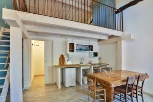 cocina y comedor con mesa de madera en Bacialupo Foresteria, en Montecalvo Versiggia