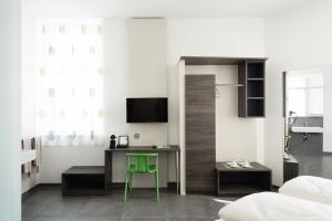 Schlafzimmer mit einem Schreibtisch, einem Bett und einem TV in der Unterkunft eee Hotel Traun in Linz