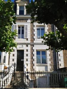 una casa bianca con una porta nera e una recinzione di 46 Avenue Pasteur a Saint Malo