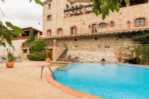 a large swimming pool in front of a building at Mas Moli Petit in Girona