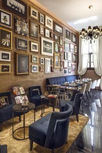 a restaurant with blue chairs and pictures on the wall at Venice Times Hotel in Venice
