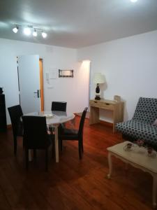 ein Wohnzimmer mit einem Tisch, Stühlen und einem Sofa in der Unterkunft beau T2 lumineux 1er etage in Rochefort