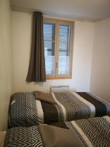 a bedroom with two beds in front of a window at beau T2 lumineux 1er etage in Rochefort