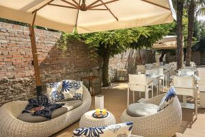 a patio with two chairs and an umbrella at Venice Times Hotel in Venice