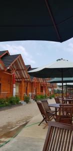 a table and chairs with an umbrella on a patio at Vila tenjo gunung in Cilowa