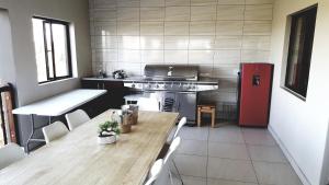 a kitchen with a table, sink, and refrigerator at Bokmakierie Place in Modimolle