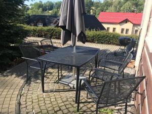 a table and chairs with an umbrella on a patio at Modern chalet Na Zlatníku in Zlatá Olešnice