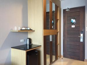 Zimmer mit einer Küche mit einer Tür und einer Theke in der Unterkunft Aqua Resort SHA Plus in Rawai Beach
