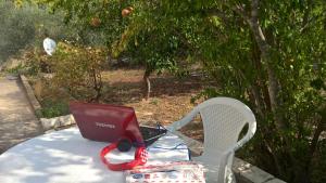 a laptop computer sitting on a table with a chair at inKorcula in Korčula