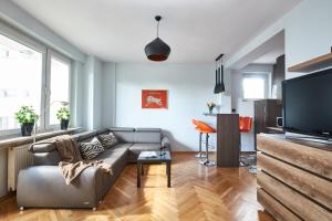 a living room with a couch and a flat screen tv at Noctis Apartment Tamka in Warsaw