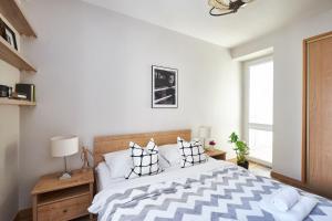 a bedroom with a large bed with black and white pillows at Noctis Apartment Tamka in Warsaw