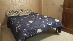 ein Bett mit einer blauen Decke mit Mond und Sternen in der Unterkunft Casa Gloria in Pallerone
