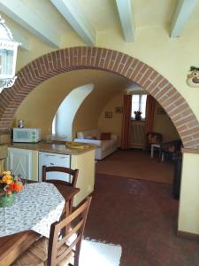 カプリーノ・ヴェロネーゼにあるCasa Del Capitelloのキッチン、アーチ道のあるリビングルーム