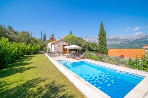 a swimming pool in a yard with a house at Villa Lucija in Gruda