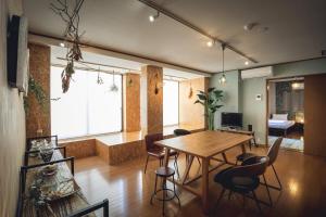 松山的住宿－3LDK Denchi，客厅配有木桌和椅子
