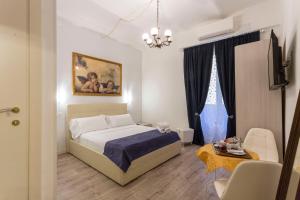 een slaapkamer met een bed, een bank en een tafel bij Hotel Cathrine in Rome