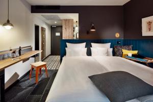 マインツにあるMe and All Hotel Mainz, by Hyattの大きなベッドと机があるホテルの部屋 +87枚の写真