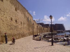 a man riding a bike next to a wall at Bel appartement face à la méditerranée in Bizerte