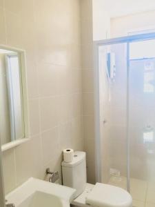 a bathroom with a toilet and a glass shower at Meridin Bayvue Serviced Apt in Kampong Kuala Masai