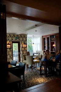 a woman sitting at a table in a living room at Anglesey Arms Hotel in Menai Bridge