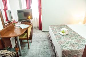 a hotel room with a desk and a bed and a computer at Hotel Parc Sibiu in Sibiu