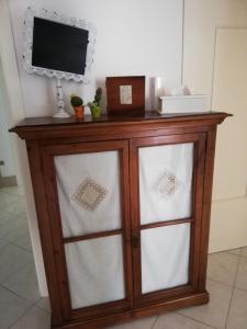 a wooden cabinet with glass doors with a tv on top at Il Vicolo di Ripa B&b in Ripatransone