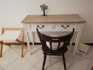 a desk with a chair and a table with a plant on it at Il Vicolo di Ripa B&b in Ripatransone