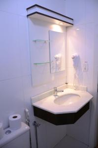 a bathroom with a sink and a mirror and a toilet at Zermatt Hotel in Gramado