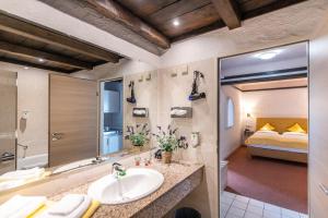 ein Bad mit einem Waschbecken und ein Bett in einem Zimmer in der Unterkunft CONTEL Hotel in Koblenz
