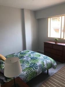 a bedroom with a bed and a dresser and a window at Campello Mistral in El Campello