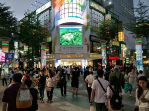 a crowd of people walking in a busy city street at night at I Play Inn TP in Taipei