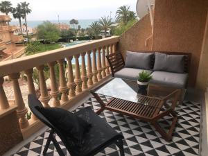 a balcony with a couch and a table and chairs at Campello Mistral in El Campello