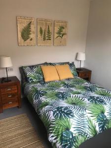 a bedroom with a bed with a bedspread with palm leaves at Campello Mistral in El Campello +19 photos