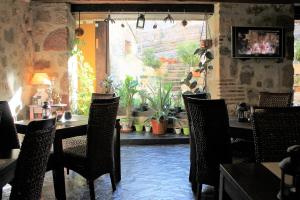 锡古恩萨Hotel Rural el Arrabal Siguenza的一间有桌椅和植物的餐厅