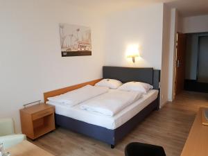 a bedroom with a large bed with white sheets at Arthotel ANA Neotel in Stuttgart