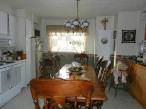 a kitchen with a table and chairs and a dining room at Domaine Joseph Ross Bed and Breakfast in Cap-Chat