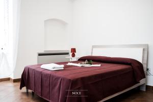 a bed with a red blanket and a table with a lamp at Tenuta Vigna del Noce in Corato