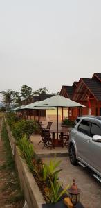 a car parked next to a patio with a table and umbrella at Vila tenjo gunung in Cilowa