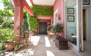 タオルミーナにあるRocca Castelloのピンクの家と植物のあるパティオ