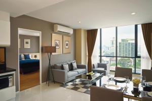 a living room with a couch and a dining room at Mövenpick Residences Ekkamai Bangkok in Bangkok