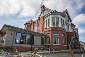 a large brick building with a sign on it at Gwesty Links in Llandudno