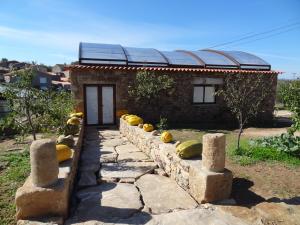 a stone path leading to a building with a solar roof at Casas do Juizo - Country Houses in Juizo