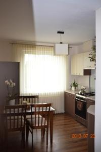 a kitchen with a table and chairs and a dining room at Apartamentai Dainų in Šiauliai