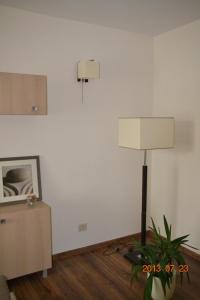 a living room with a lamp and a plant at Apartamentai Dainų in Šiauliai