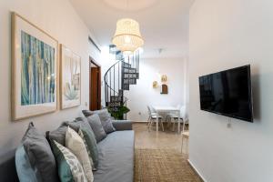 sala de estar con sofá y TV de pantalla plana en Apartamentos San Lorenzo, en Sevilla