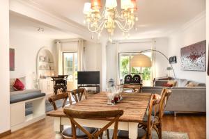 - un salon avec une table et des chaises en bois dans l'établissement Jardim Das Flores Luxury Apartment, à Lisbonne