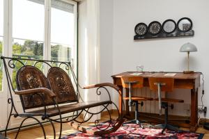 リスボンにあるJardim Das Flores Luxury Apartmentのデスク、椅子2脚、テーブルが備わる客室です。