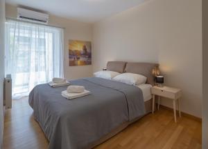 um quarto com uma cama com duas toalhas em Sagittarius - Faliro Sea Side apartment em Atenas