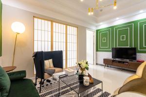 Elle comprend un salon avec des murs verts et une télévision. dans l'établissement Wuhan Hongshan·Guanggu Square· Locals Apartment 00157650, à Wuhan